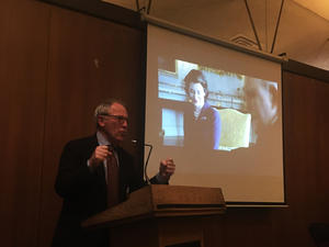 Thomas Laqueur stands in front of projected video clip of The Crown.