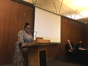 Stephanie-Jones Rogers, speaks at a podium in foreground. Thomas Laqueur and David Henkin are visible in background.